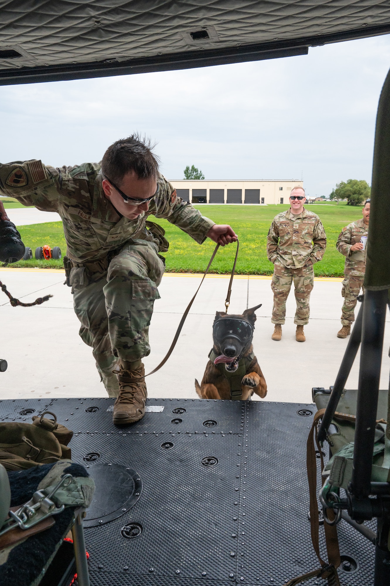 A U.S. Air Force military working dog handler and his dog board a helicopter.