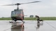A U.S. Air Force military working dog handler and his dog run to board a helicopter in the rain.