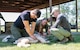 A U.S. Army veterinary commanding officer instructs two Airmen on Tactical Combat Casualty Care procedures for dogs on a canine manikin.
