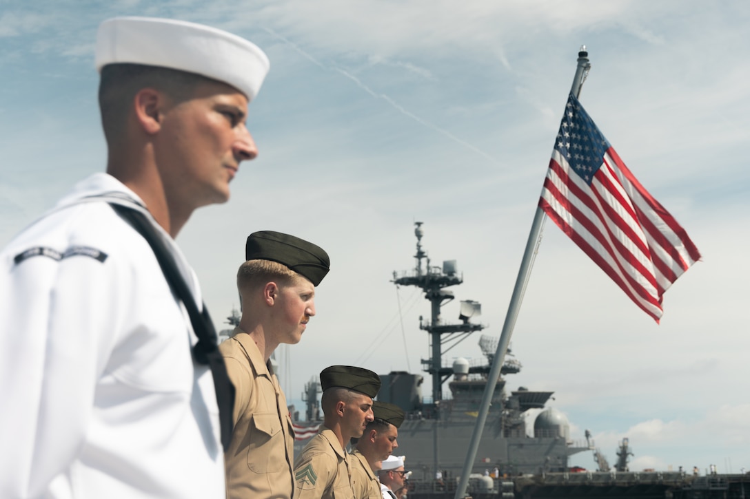 U.S. Marines with the 22nd Marine Expeditionary Unit (Special Operations Capable), and U.S. Navy sailors with the San Antonio-class amphibious transport dock ship USS San Antonio (LPD 17), Iwo Jima Amphibious Ready Group, depart for deployment during a man the rails ceremony aboard the San Antonio while in port at Naval Station Norfolk, Virginia, August 14, 2025. This ceremony signifies that the IWO ARG and 22d Marine Expeditionary Unit (Special Operations Capable) are officially underway for their regularly scheduled deployment. (U.S. Marine Corps photo by Cpl. Maurion Moore)