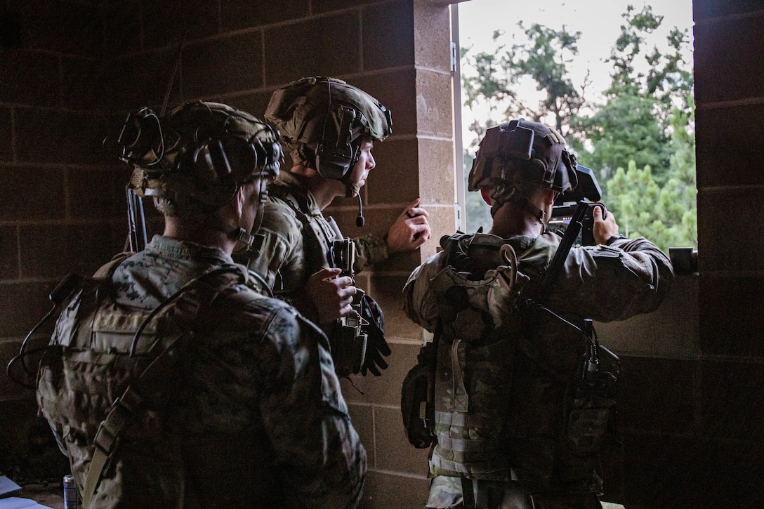 U.S. Marine Corps Sgt. Justin Marioth, left, a team chief, with 1st Air Naval Gunfire Liaison Company, I Marine Expeditionary Force Information Group, U.S. Army Staff Sgt. Clifford Stahl, center, the senior logistics advisor with Alpha Battery, 2nd Battalion, 5th Security Force Assistance Brigade, and U.S. Army Sgt. Jacob Crowson, a medical advisor, with Alpha Battery, 2nd Battalion, 5th Security Forces Assistance Brigade, observe a small unmanned aerial system during an urban defense at Camp Grayling, Michigan, Aug. 9, 2025. Marines at Northern Strike 25 continue to train and enhance the survivability and the lethality of the naval expeditionary force while fully integrating with joint forces and multinational partners. (U.S. Marine Corps photo by Cpl. Peyton Kahle)