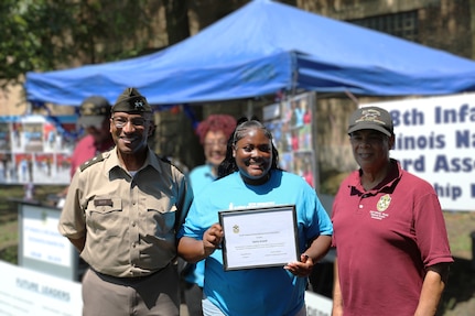 Maj. Gen. Rodney Boyd joins members in presenting a scholarship to Sania Sneed
