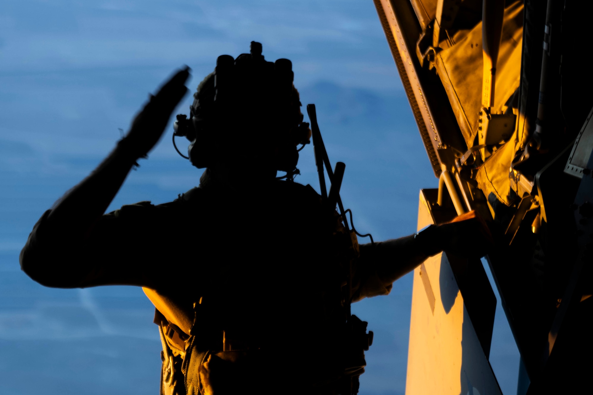 An AFSOC Air Commando signals to the jumpers during a military free fall insertion during Emerald Warrior 25.2.