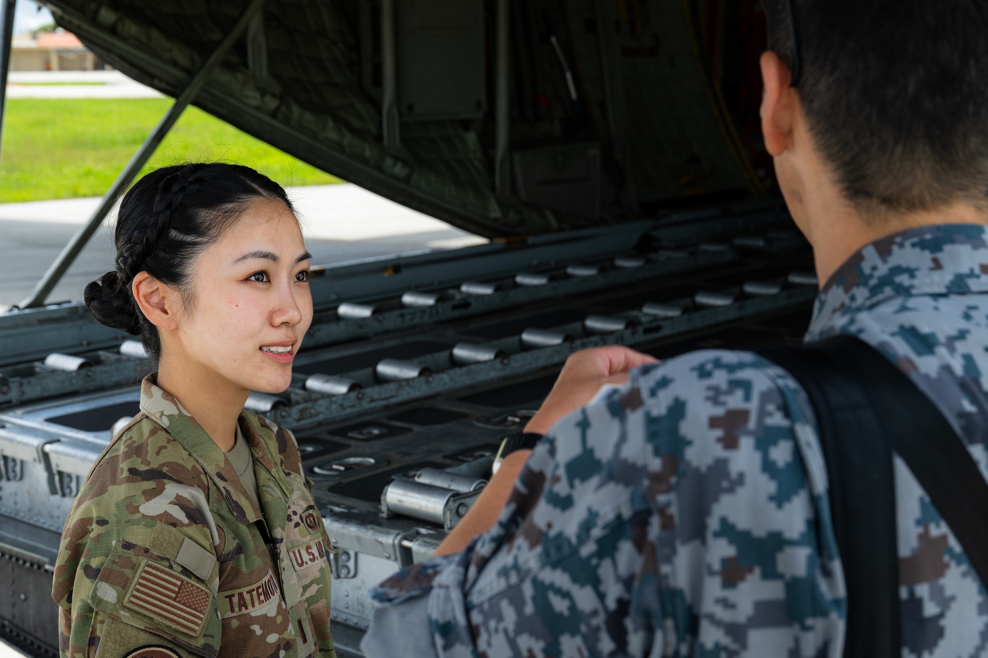 U.S. Air Force 2nd Lt. Julie Tatemoto, left, 51st Operations Support Squadron airfield operations director of operations and Language Enabled Airman Program participant, Osan Air Base, South Korea, talks with a member of the Japan Air Self-Defense Force during the U.S. Air Force’s 2025 Department-Level Exercise series at Andersen Air Force Base, Guam, July 22, 2025. LEAP empowers the DLE by enhancing linguistic and cultural interoperability, enabling more effective collaboration and mission success with partners and allies. DLE 2025 is a new way of conducting operations in a contested, dynamic environment to build capabilities, making a stronger, more lethal deterrent force. The DLE encompasses all branches of the Department of Defense, along with Allies and partners, employing more than 400 Joint and coalition aircraft and more than 12,000 members at more than 50 locations across 3,000 miles. (U.S. Air Force photo by Senior Airman Jade M. Caldwell)