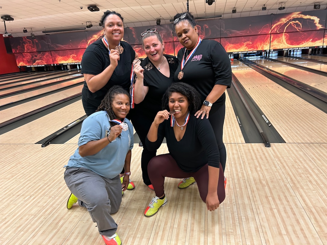 Five women hold bronze medals