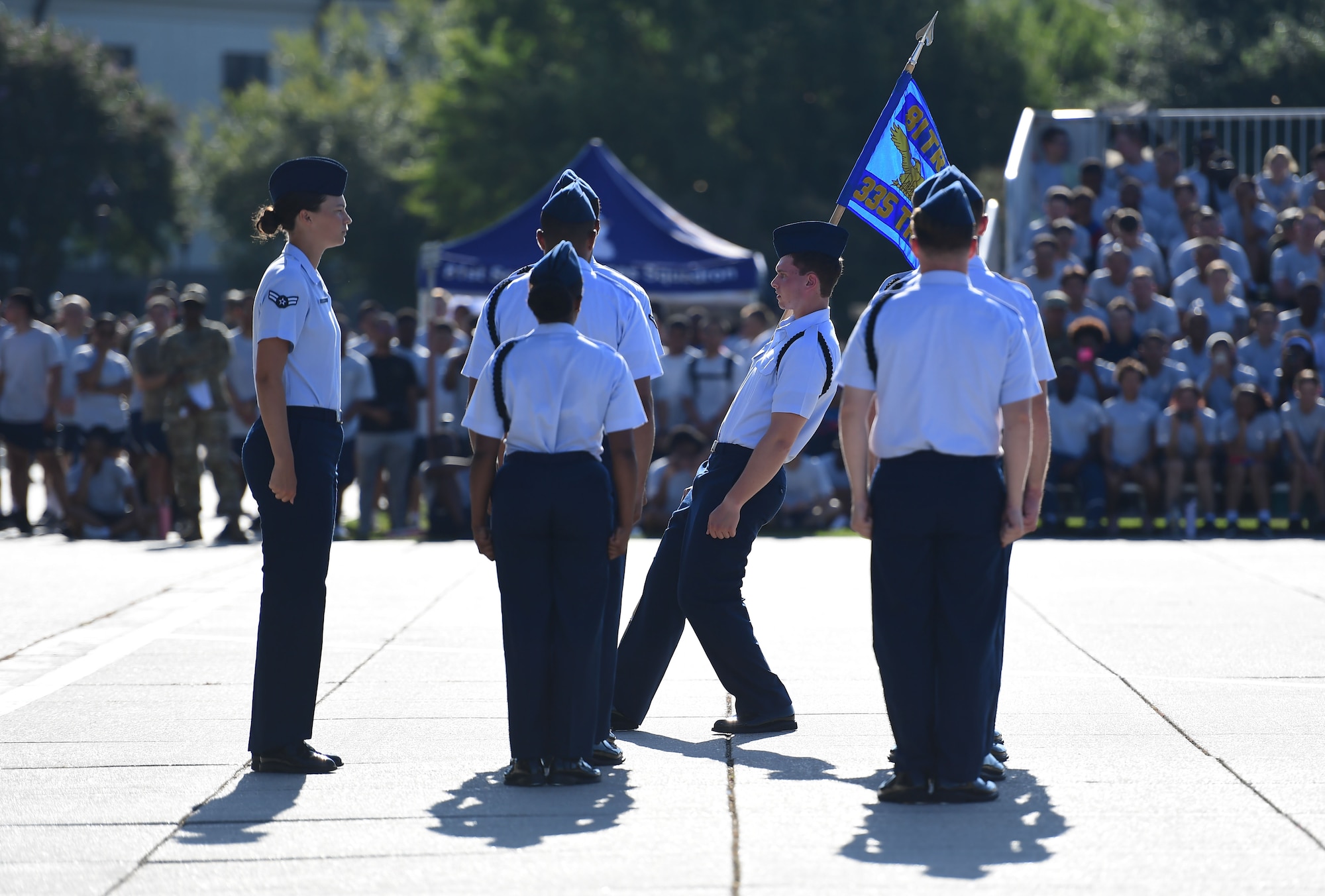 A group of people wearing military uniform stand in formation.