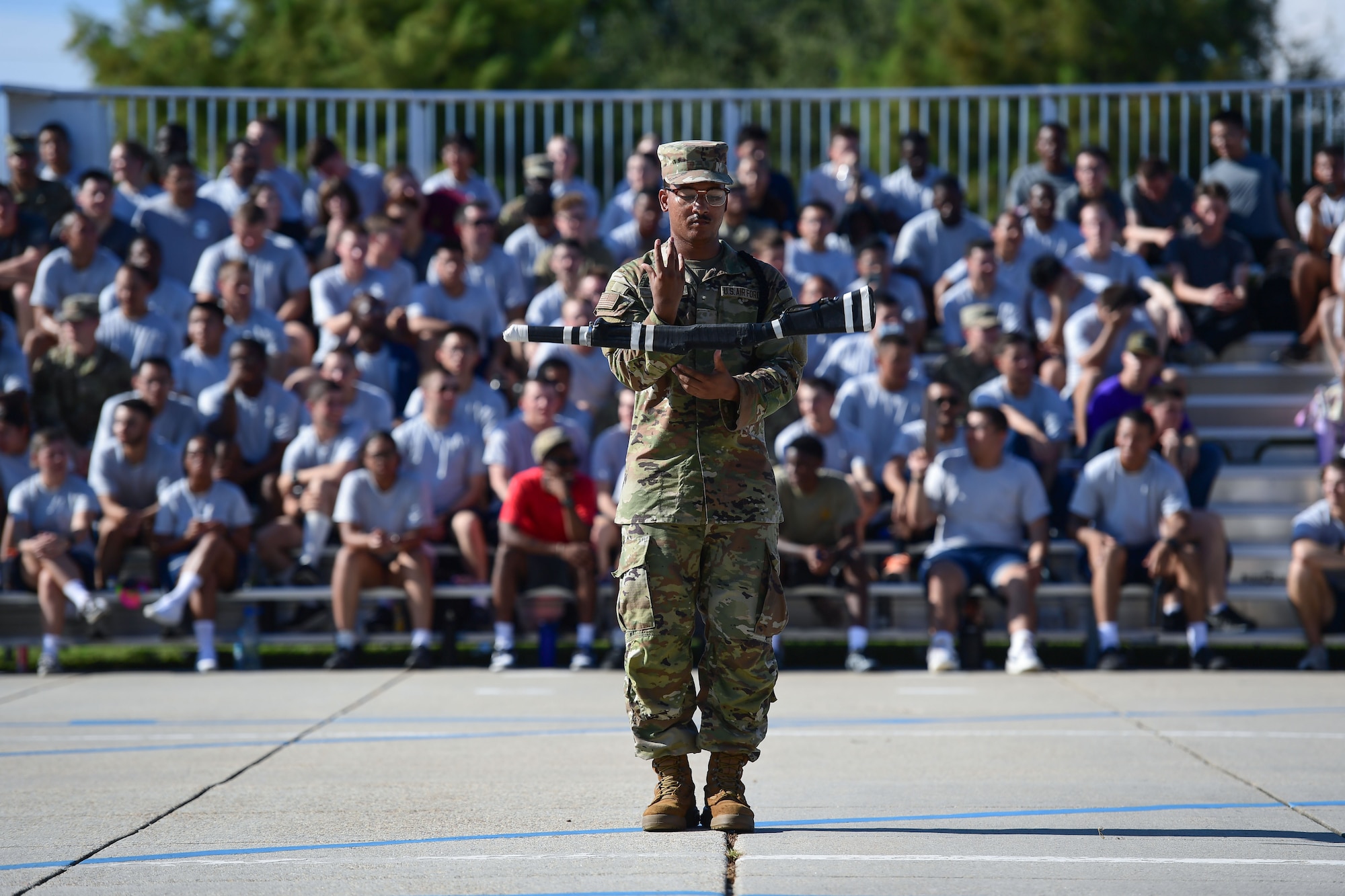 A man in military uniform spins a static weapon in the air.