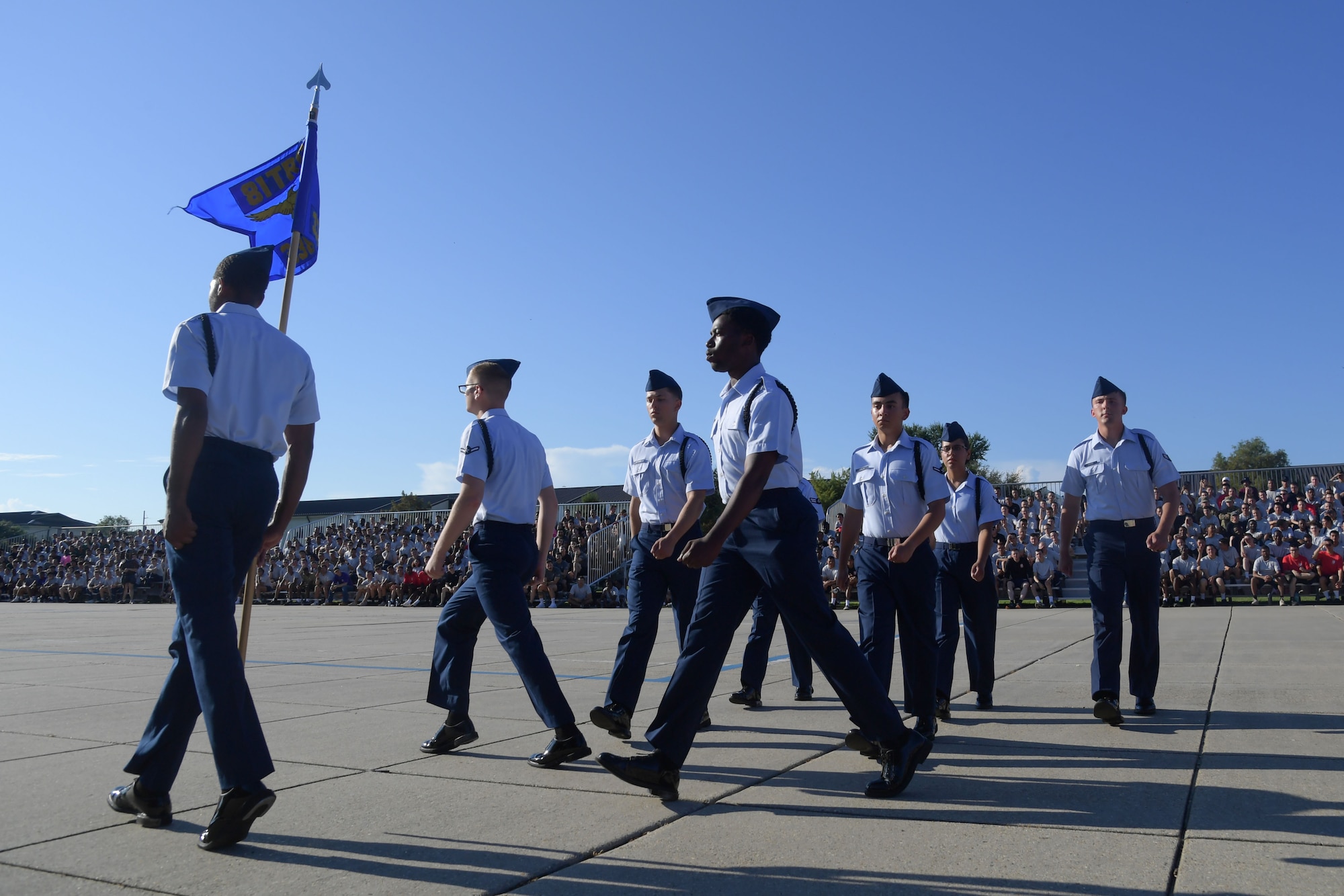 A group of people in military uniform march in formation
