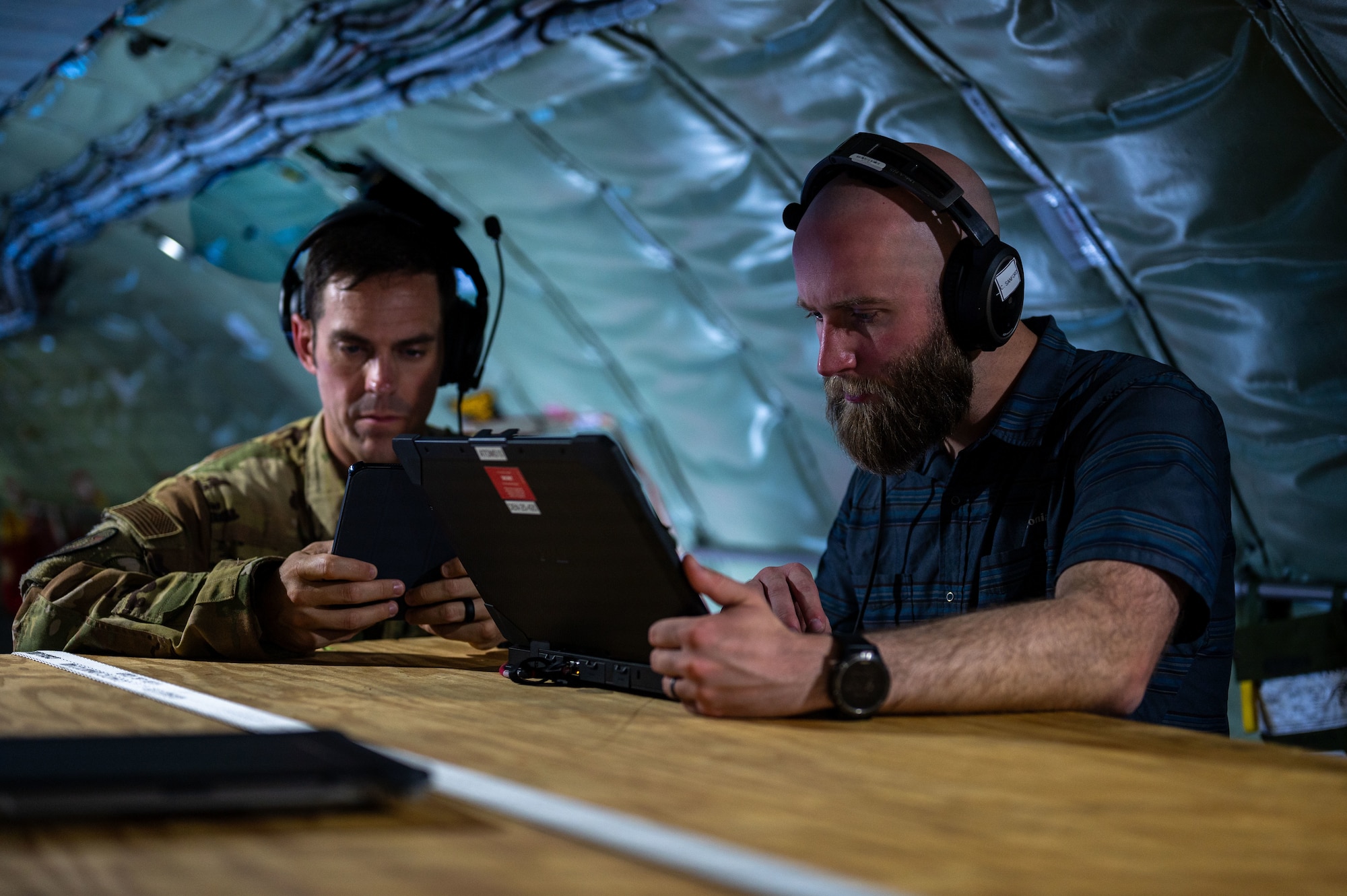 U.S. Air Force Lt. Col. Paul Tucker, Commander’s Initiative Group director for the Air Mobility Command Headquarters, left, and Clark Sanford, project engineer for Sierra Nevada Corporation, perform receiver locating on a Airlift Tanker Open Mission System using beyond line of sight during the U.S. Air Force’s 2025 Department-Level Exercise at Andersen Air Force Base, Guam, July 15, 2025. AMC's support to the Department-Level Exercise strengthens and demonstrates the U.S. Air Force’s ability to reach theater at speed and scale, sustain operations, and rapidly pivot to any theater of operation at a moment’s notice, while maintaining the strategic initiative. The DLE series encompasses all branches of the Department of Defense, along with Allies and partners, employing more than 400 Joint and coalition aircraft and more than 12,000 members at more than 50 locations across 3,000 miles. (U.S. Air Force photo by Senior Airman Brooklyn Golightly)