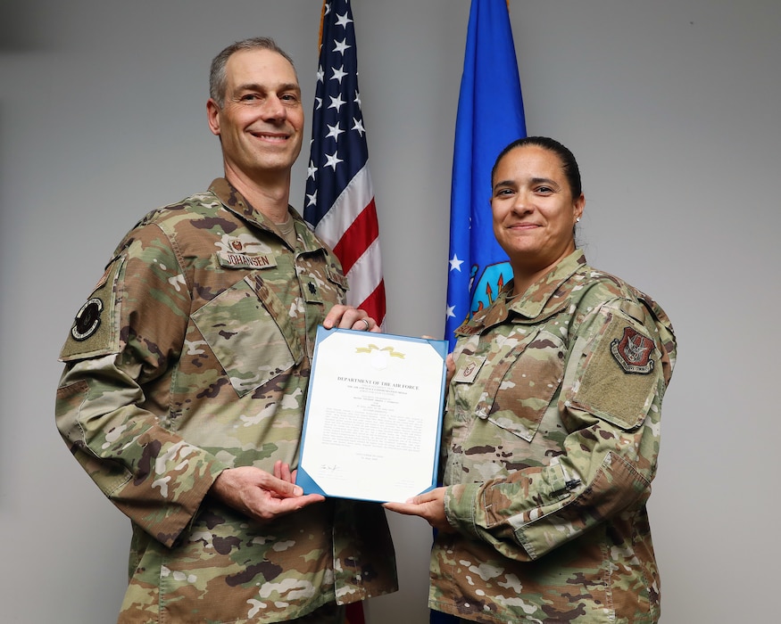 U.S. Air Force Lt. Col. Timothy Johansen, 445th Force Support Squadron commander, presents Master Sgt. Amanda Szymanski, 445th FSS personnel technician, with the Air and Space Commendation Medal at Wright-Patterson Air Force Base, Ohio, Aug. 3, 2025. Szymanski distinguished herself by providing first aid to an injured woman while on a camping trip July 26, 2025. (U.S. Air Force photo by Amanda Dick)