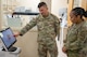 U.S. Air Force Chief Master Sgt. Tanya Johnson, Defense Health Agency senior enlisted leader, receives a dental lab briefing from U.S. Air Force Staff Sgt. Christopher Carpe, 5th Medical Group dental assistant on Minot Air Force Base, North Dakota on Aug.13, 2025.