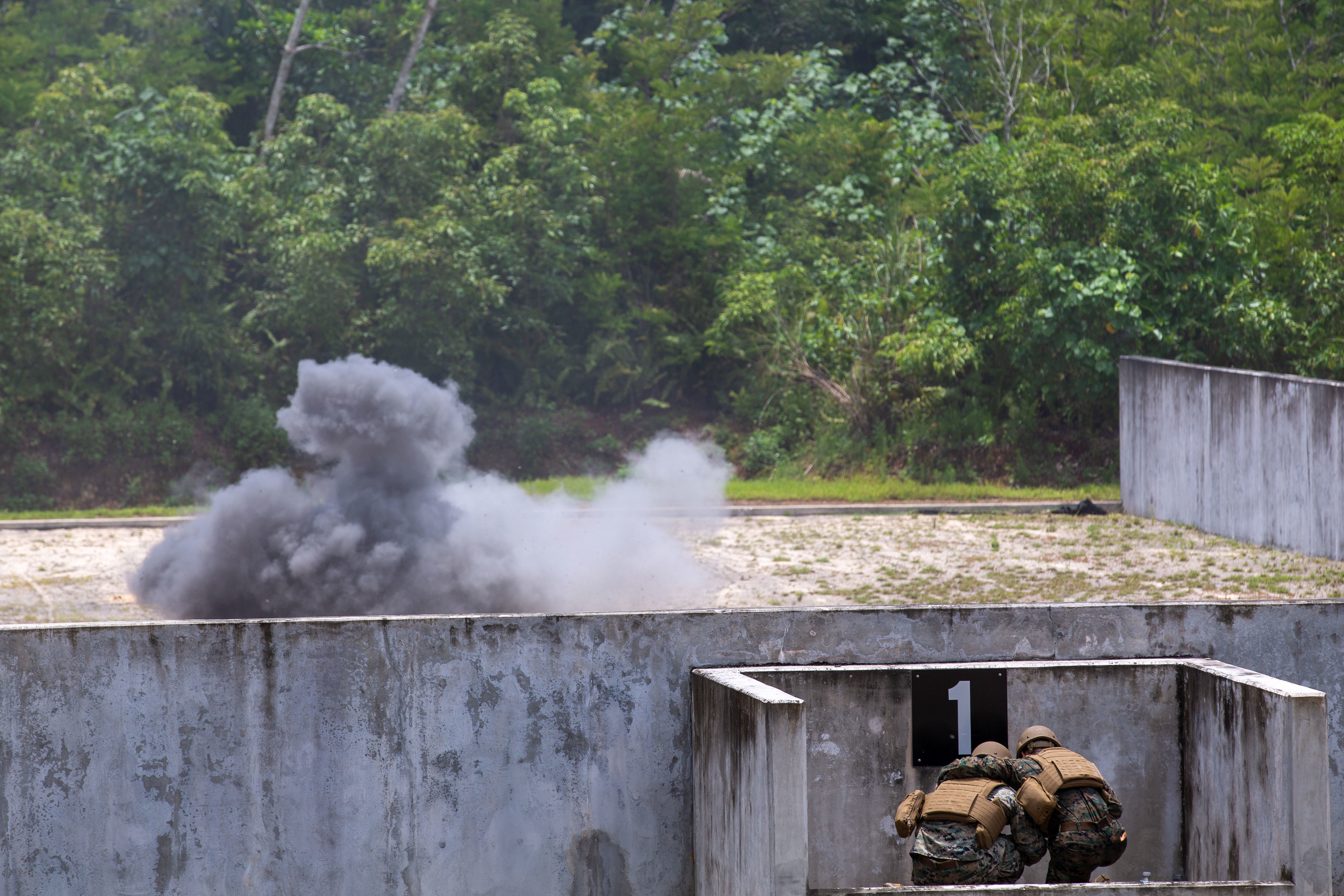 U.S. Marines with Combat Logistics Company 34, Combat Logistics Regiment 37, 3rd Marine Logistics Group, take cover after throwing an M67 grenade, during a grenade range on Skaggs Urban Training Complex, Marine Corps Base Camp Blaz, Guam, Aug. 8, 2025. Marines executed the M67 grenade range to enhance combat readiness. This grenade range was the first one to be conducted on Skaggs UTC. (U.S. Marine Corps photo by Lance Cpl. Afton Smiley)