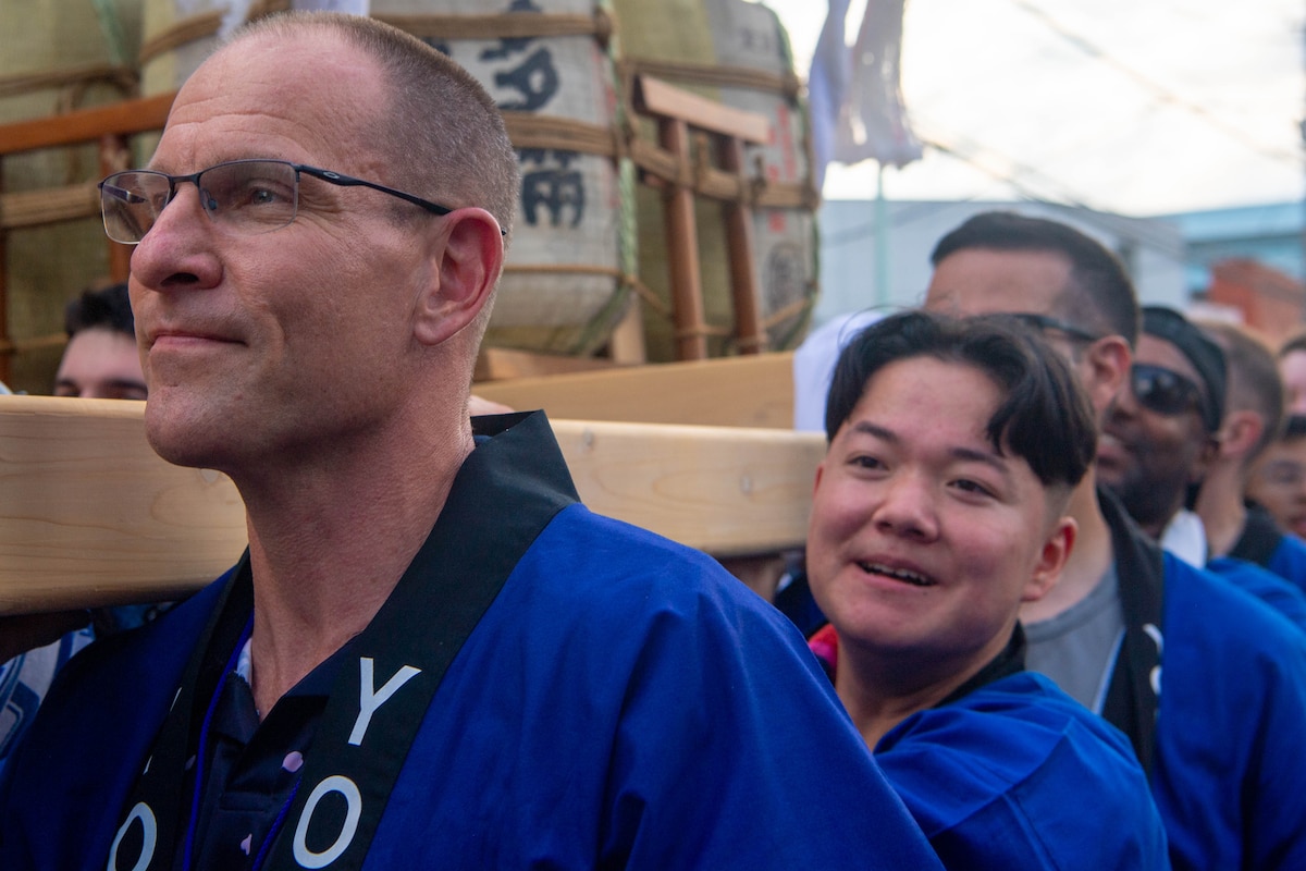 A man helps carry a mikoshi.