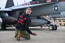 U.S. Navy Petty Officer 3rd Class Prince Webb, an Electronic Attack Squadron (VAQ-132) aviation structural mechanic from Naval Air Station Whidbey Island, Wash., marshals an EA-18G Growler during exercise Northern Edge 2025 at Eielson Air Force Base, Alaska, Aug. 17, 2025.
