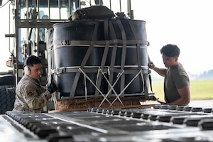 Airmen load a container delivery system bundle onto a C-130J Super Hercules.