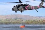 A UH-60 Black Hawk picks up water from a pond near the Rancho Fire about 30 miles north of Reno on Friday, Aug. 15, 2025. Nevada Army National Guard aviators activated 22 Soldiers on Aug. 3 operating one CH-47 Chinook and one UH-60 Black Hawk from the Army Aviation Support Facility at Stead to support the Nevada Division of Forestry in Elko County. Days after coming off orders for that fire, Army aviators were called for the Rancho Fire. Orders ended this weekend after the fire's forward progression was halted.