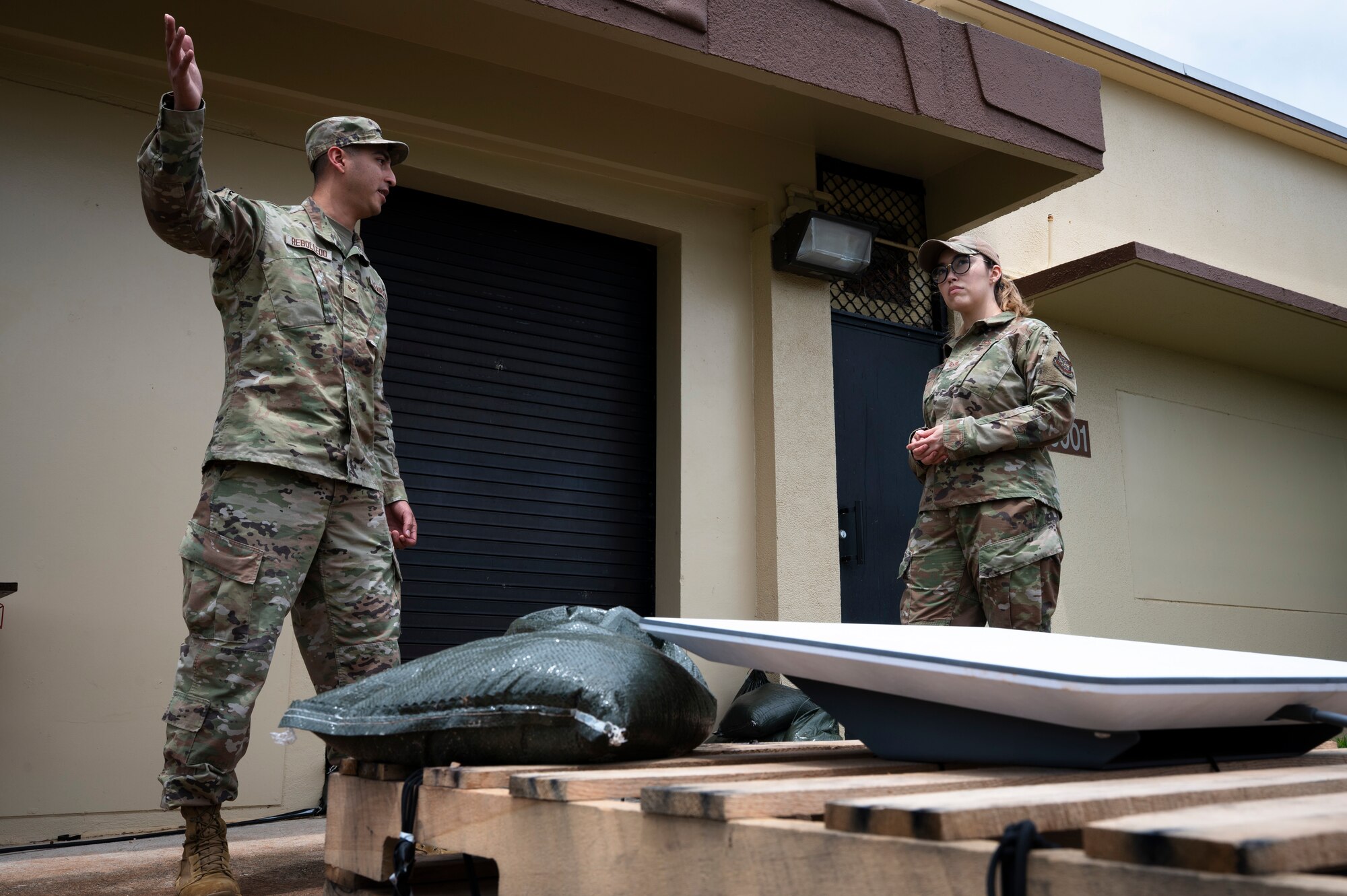 U.S. Air Force Senior Airman Francisco Rebolledo, a radio frequency transmission technician assigned to the 19th Communications Squadron, briefs Tech. Sgt. Evizia Zorro, occupational safety specialist assigned to the 87th Air Base Wing, on how he safely secured communication equipment and ensured continued communication for  aircrew during heavy winds at Andersen Air Force Base, Guam, during the Air Force’s 2025 Department-Level Exercise series, July 28, 2025. Air Mobility Command safety personnel ensured mission readiness by identifying hazards and mitigating risks for Airmen during the DLE. The DLE series encompasses all branches of the Department of Defense, along with allies and partners, employing more than 400 Joint and coalition aircraft and more than 12,000 members at more than 50 locations across 3,000 miles. (U.S. Air Force photo by Staff Sgt. Dalton Williams)