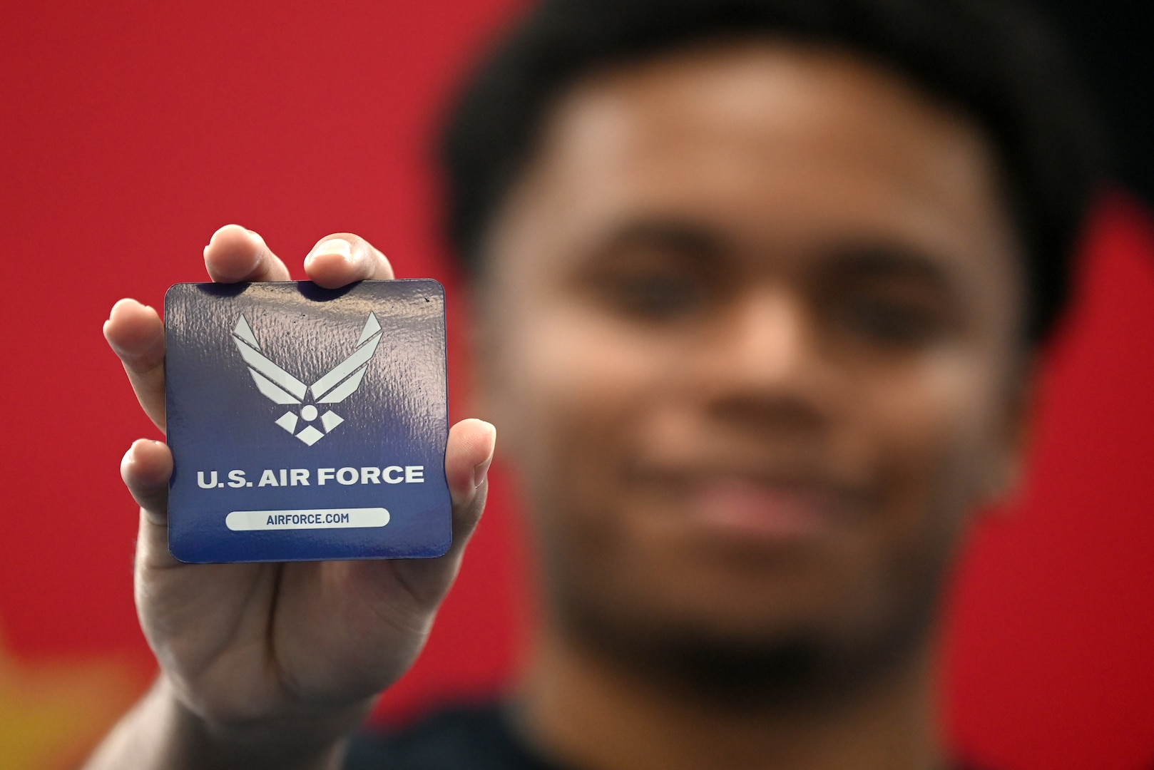 A member of the Delayed Entry Program holds up an Air Force magnet before a Swearing In ceremony hosted by Deputy Commander of Air Force Recruiting Service Brig. Gen. Craig McPike at the Rayburn Office Building, Washington, D.C. Aug 15, 2025. McPike was on hand to host a Swearing In ceremony for the members. (U.S. Air Force photo by Andy Morataya)
