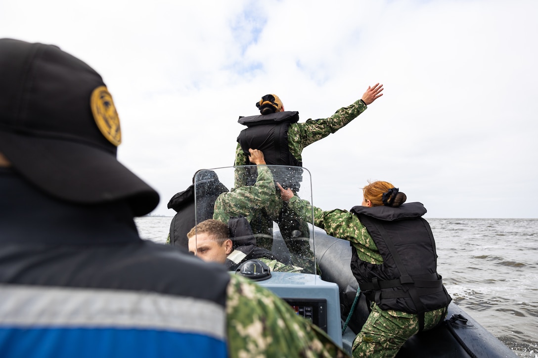 Uruguayan Infantes de Marina demonstrate hand and arm signals on rigid inflatable boats during a subject matter expert exchange in Uruguay, August 14, 2025. This subject matter expert exchange enhances the training and readiness standards for the United States and Uruguay as well as facilitating the exchange of formalized readiness standards between both countries. (U.S. Marine Corps photo by Sgt. Eduardo Delatorre)