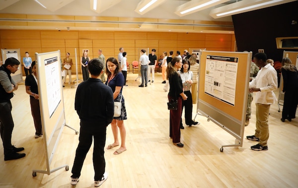 SILVER SPRING, Md. (Aug. 12, 2025) Naval Medical Research Command (NMRC) Interns with Naval Research Enterprise Internship Program (NREIP) and Science and Engineering Apprenticeship Program (SEAP) discuss research undertaken during the summer alongside Navy scientists with command staff during a STEM day exhibit. NMRC, headquarters of Navy Medicine Research & Development, is engaged in a broad spectrum of activity from basic science in the laboratory to field studies in austere and remote areas of the world to investigations in operational environments. In support of Navy, Marine Corps and joint U.S. warfighter health, readiness and lethality, researchers study infectious diseases, biological warfare detection and defense, combat casualty care, environmental health concerns, aerospace and undersea medicine, operational mission support and epidemiology. (U.S. Navy Photo by Sidney Hinds/ released)