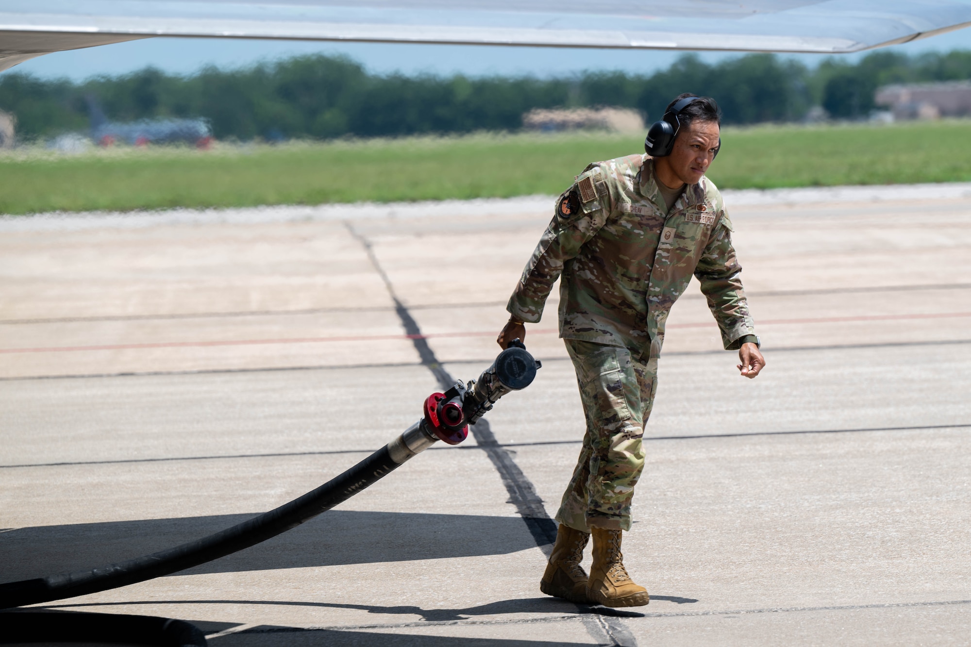 A man pulls a hose across the photo