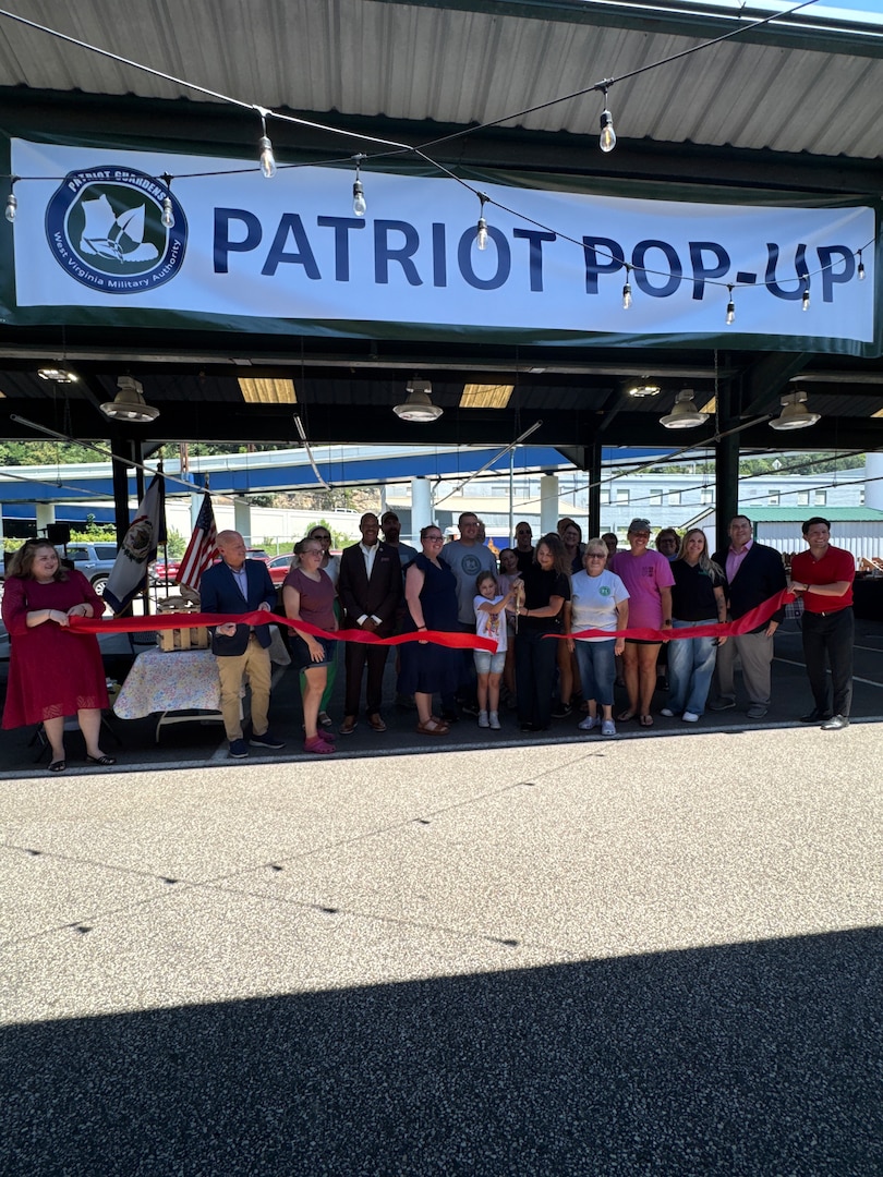 group of people cutting red ribbon