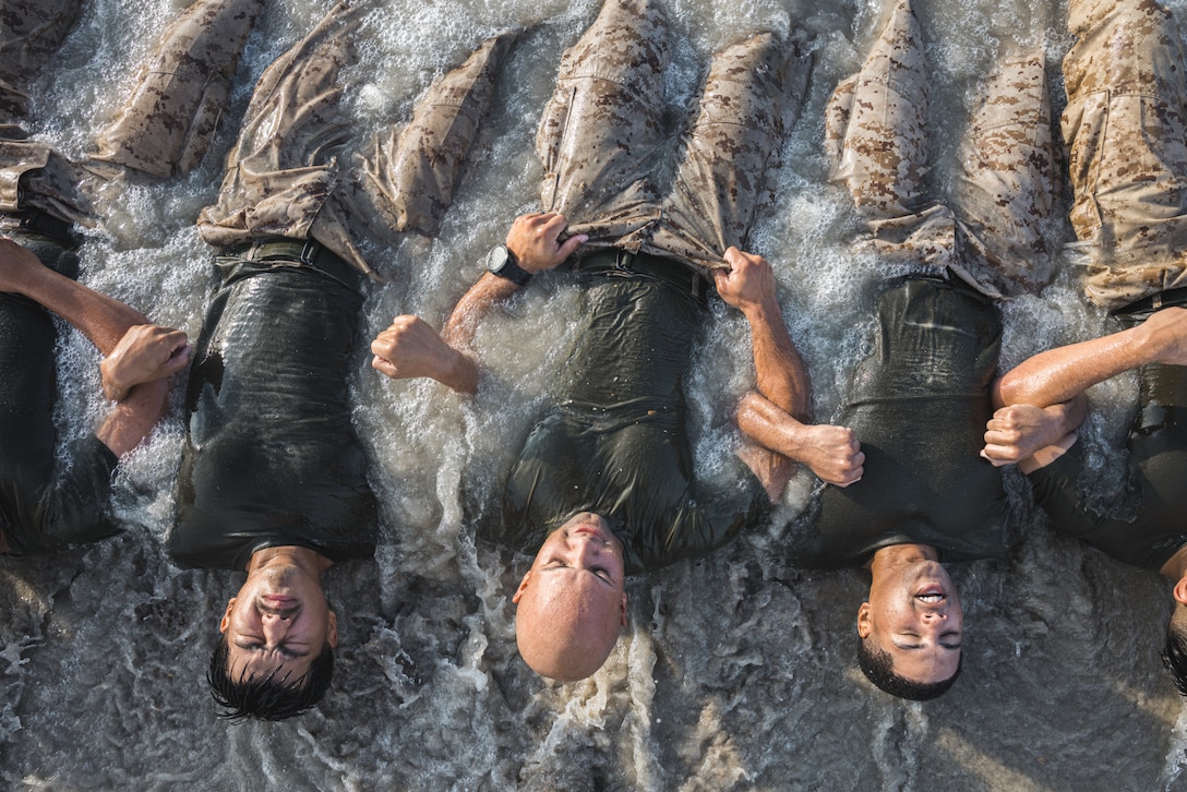 U.S. Marines from II Marine Expeditionary Force perform group sit-ups during a beach workout while participating in Corporals Leadership School on Marine Corps Base Camp Lejeune, North Carolina, Aug. 13, 2025. Corporals Leadership School is a four-week course designed to enhance skills to be effective small unit leaders and expand their knowledge as noncommissioned officers in the U.S. Marine Corps. (U.S. Marine Corps photo by Cpl. Meshaq Hylton)