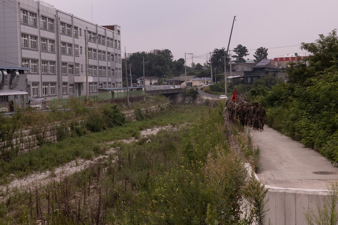 U.S. Marines with 2nd Battalion 2nd Battalion, 23rd Marines, forward deployed with 4th Marine Regiment, 3d Marine Division as part of the Unit Deployment Program, march back to Camp Mujuk after an end of exercise celebration competition as part of the Korean Marine Exercise Program 25.2 in Pohang, South Korea, Aug. 9, 2025. KMEP is conducted regularly between the ROK and U.S. Marine Corps to increase their combined capabilities through realistic training geared towards deterrence and maintaining peace in the Indo-Pacific.  (U.S. Marine Corps photo by Cpl. Kanoa Thomas)