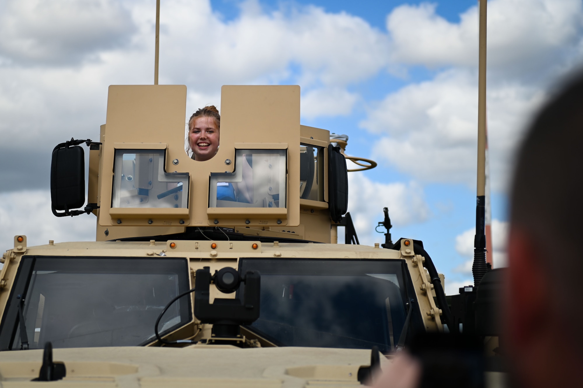 Grace Whyment, daughter of Dan Whyment, representative of Forestry England, poses for a picture inside of a Joint Light Tactical Vehicle during the static display portion of the 100th ARW’s Key Leader Engagement Day on RAF Mildenhall, England, Aug. 14, 2025.
