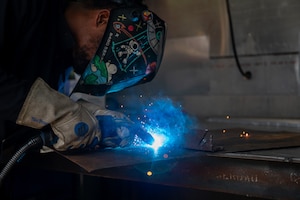 Airman welds two metal components together