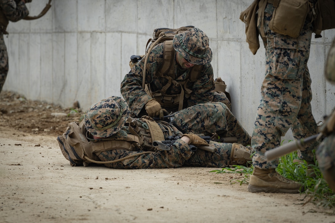 U.S. Marine Corps Sgt. Michael Collins, a machine gunner with 2nd Battalion, 23rd Marines, forward deployed with 4th Marine Regiment, 3d Marine Division as part of the Unit Deployment Program, applies a tourniquet to a simulated casualty during an amphibious assault during the Korean Marine Exercise Program 25.2 in Pohang, South Korea, August 5, 2025. KMEP is conducted regularly between the ROK and U.S. Marine Corps to increase their combined capabilities through realistic training geared towards deterrence and maintaining peace in the Indo-Pacific. (U.S. Marine Corps photo by Lance Cpl. Van Hoang)