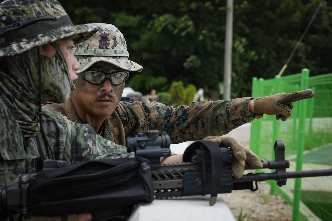 A U.S. Marine with 2nd Battalion, 23rd Marines, forward deployed with 4th Marine Regiment, 3d Marine Division as part of the Unit Deployment Program, identifies targets to a Republic of Korea Marine to coordinate suppressive fires on a simulated enemy positions during the Korean Marine Exercise Program 25.2 in Pohang, South Korea, August 5, 2025. KMEP is conducted regularly between the ROK and U.S. Marine Corps to increase their combined capabilities through realistic training geared towards deterrence and maintaining peace in the Indo-Pacific. (U.S. Marine Corps photo by Lance Cpl. Van Hoang)