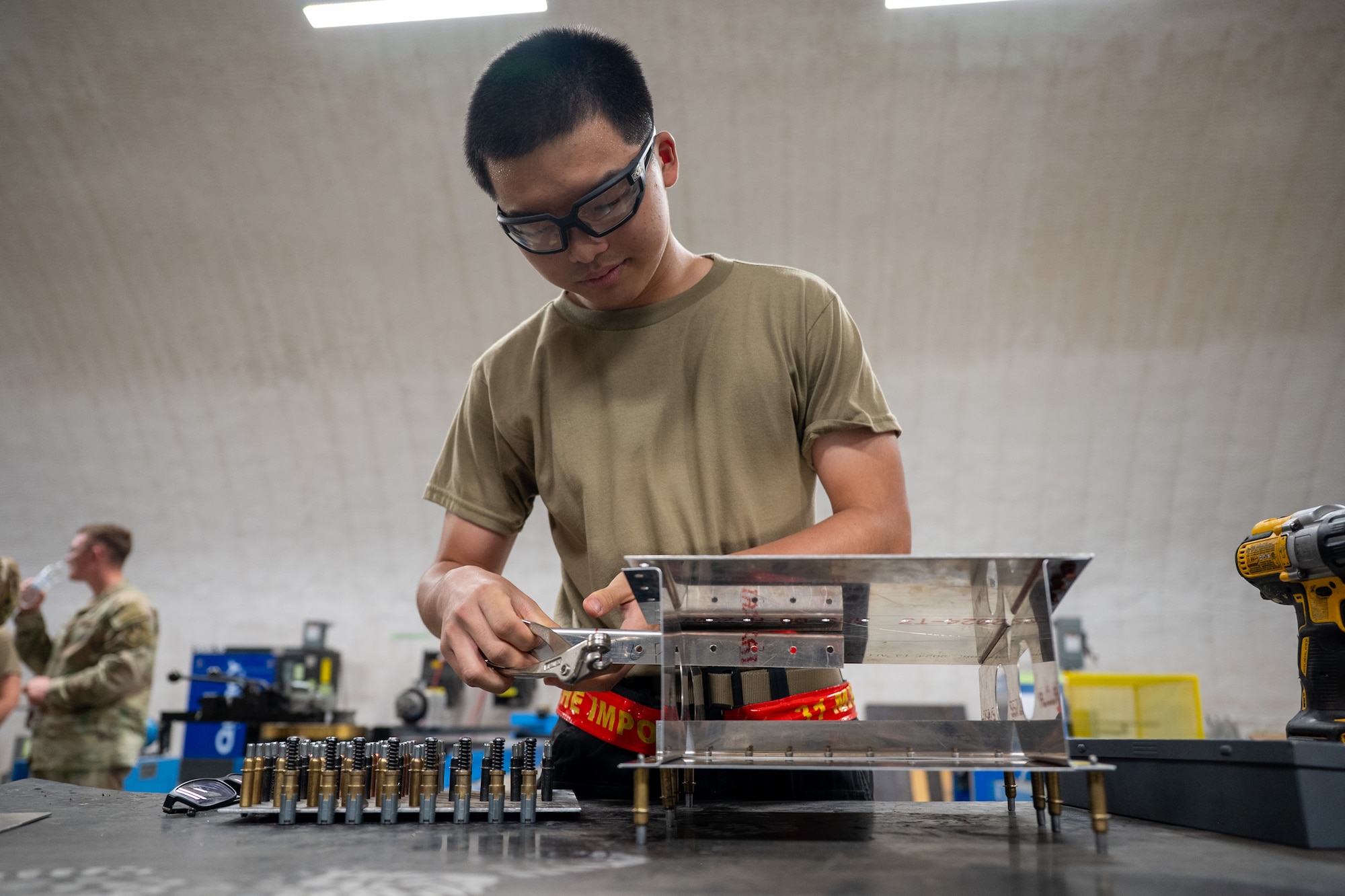 Airman prepares a simulated aircraft structure for maintenance