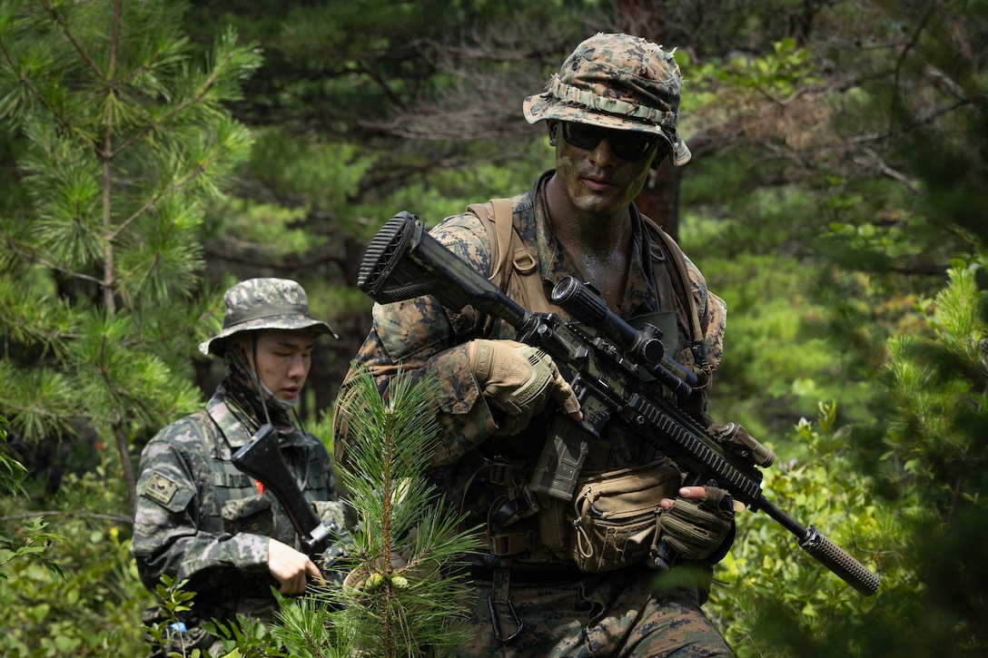U.S. Marine Corps Sgt. Joshiwa Juni, a squad leader with 2nd Battalion, 23rd Marines, forward deployed with 4th Marine Regiment, 3d Marine Division as part of the Unit Deployment Program, and a Republic of Korea Marine patrol together toward simulated enemy positions during the Korean Marine Exercise Program 25.2 in Pohang, South Korea, August 5, 2025. KMEP is conducted regularly between the ROK and U.S. Marine Corps to increase their combined capabilities through realistic training geared towards deterrence and maintaining peace in the Indo-Pacific. (U.S. Marine Corps photo by Lance Cpl. Van Hoang)
