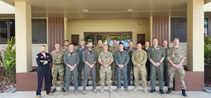 Royal Air Force and Royal Australian Air Force members stand outside of a building