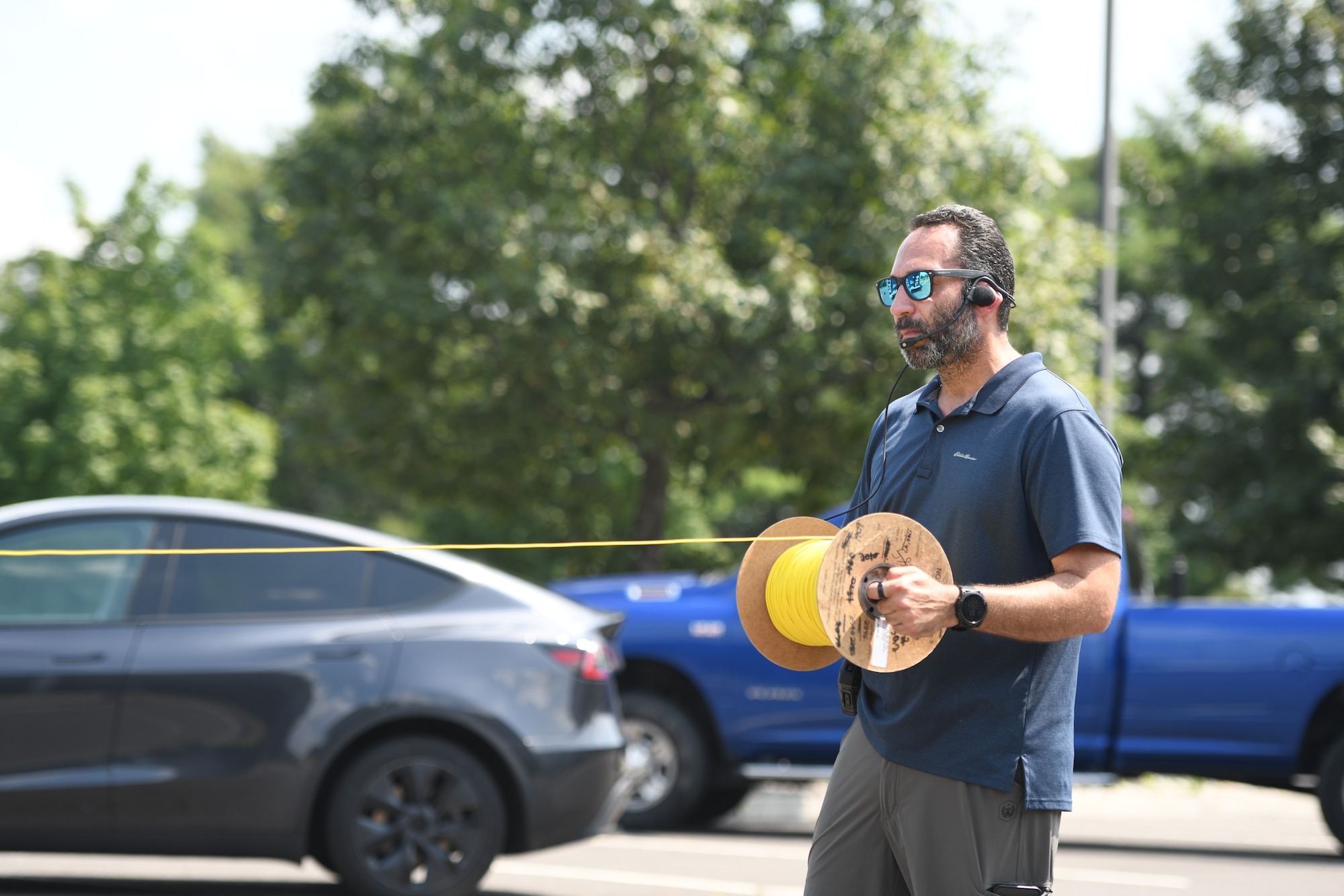U.S. Air Force Master Sgt. David Bernal, 177th Civil Engineer Squadron explosive ordnance disposal team superintendent, unspools a cable connected to Staff Sgt. Russell Bongiovanni, 177th EOD team technician, during a training exercise at Mercer County Park, West Windsor Township, New Jersey, July 31, 2025.