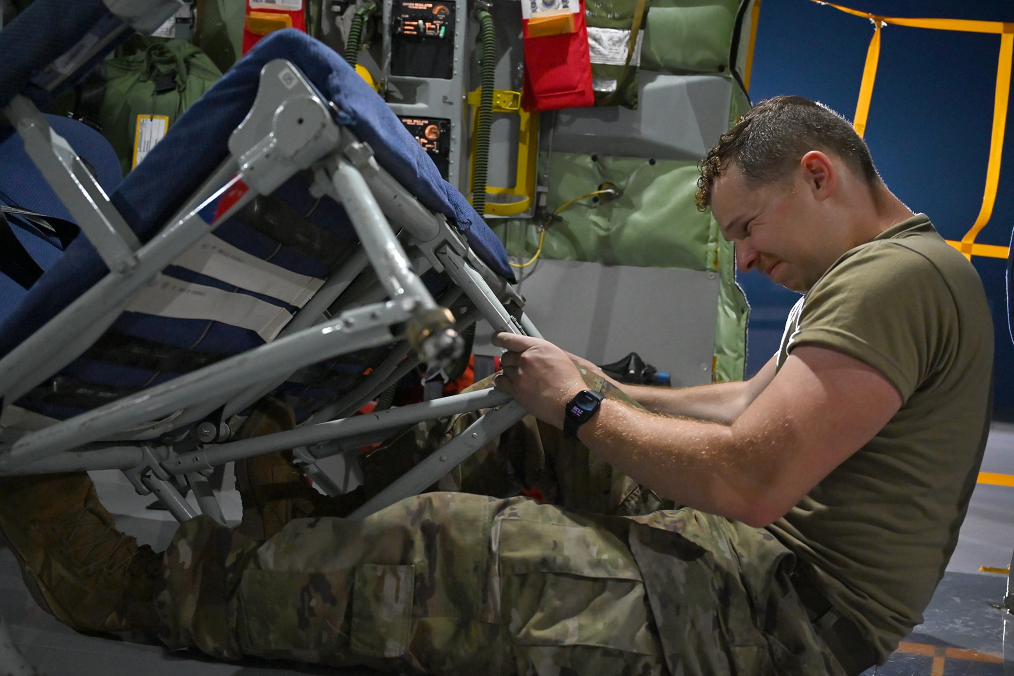 Crew chief sets up seating in the interior of a KC-135R Stratotanker