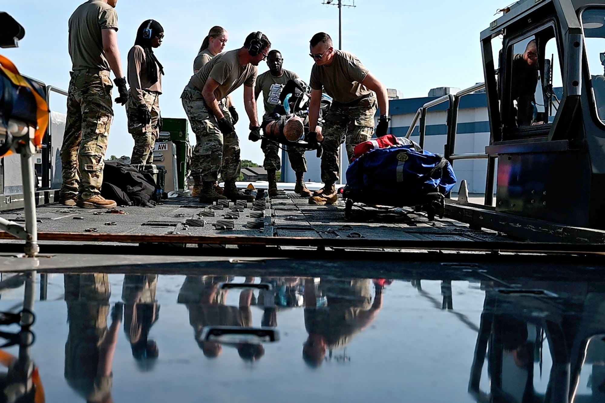Airmen participating in exercise Patriot Medic 25 carry a simulated casualty onto a KC-135R Stratotanker