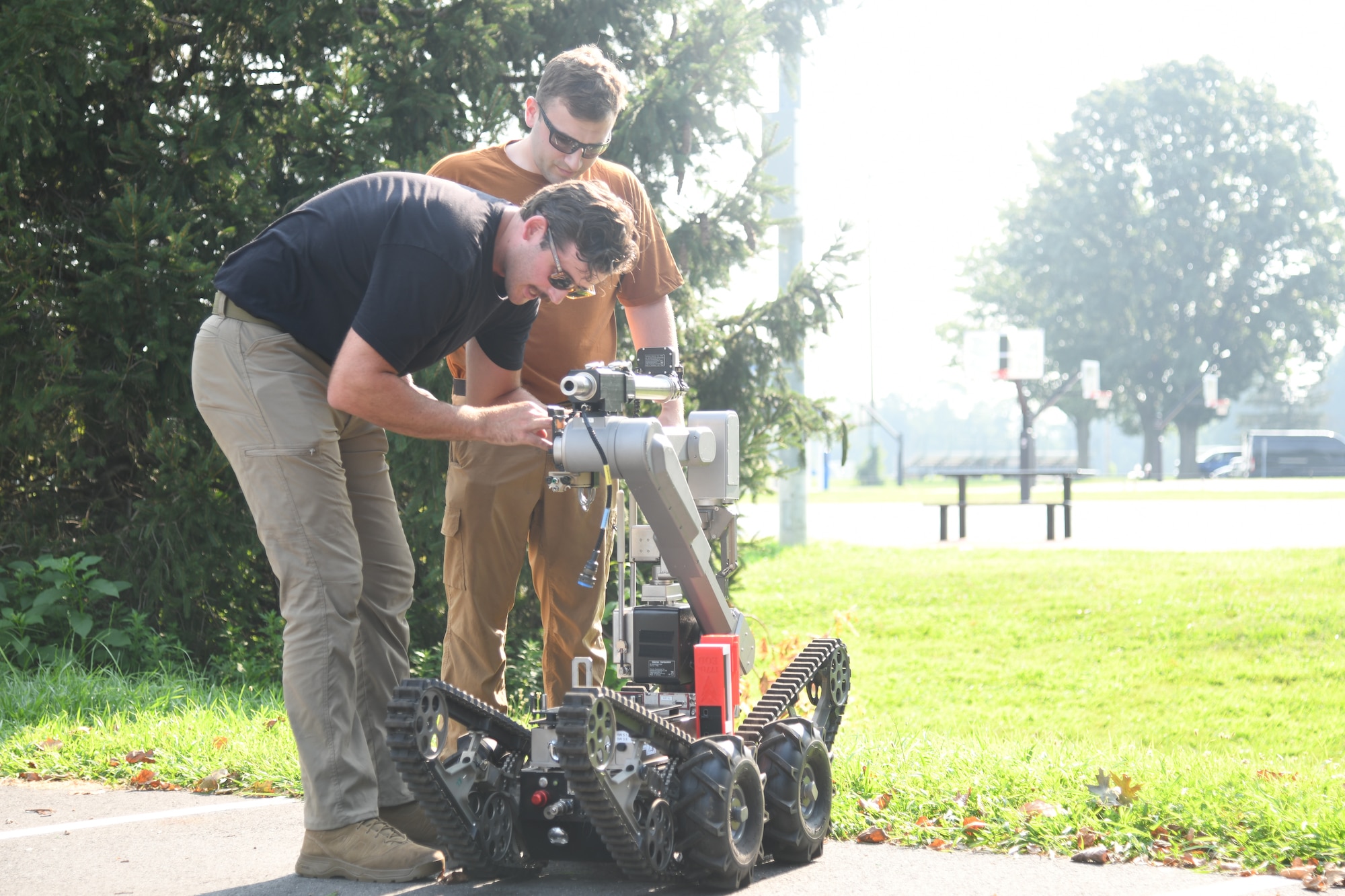 U.S. Air Force Staff Sgt. Russell Bongiovanni, 177th Explosive Ordnance Disposal team technician, back, oversees Senior Airman Robert Wittig, 177th Fighter Wing EOD team technician, work on a Man Transportable Robotics system during an exercise at Mercer County Park, West Windsor Township, West Windsor Township, New Jersey, July 31, 2025.