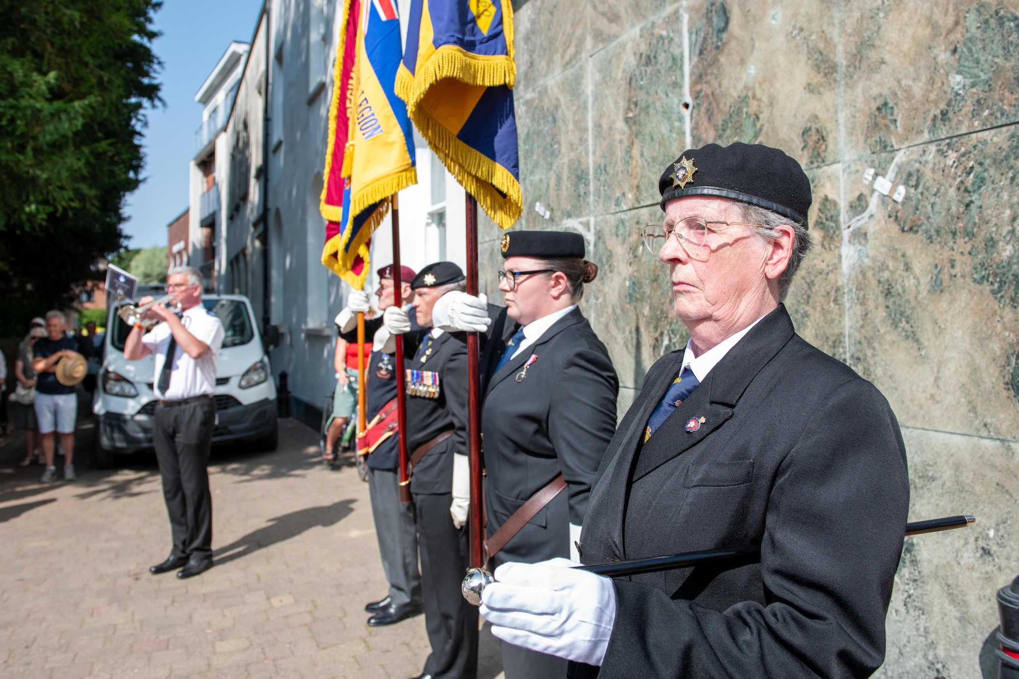 Standard bearers stand in formation as a bugler plays during the 80th anniversary Victory over Japan Day ceremony