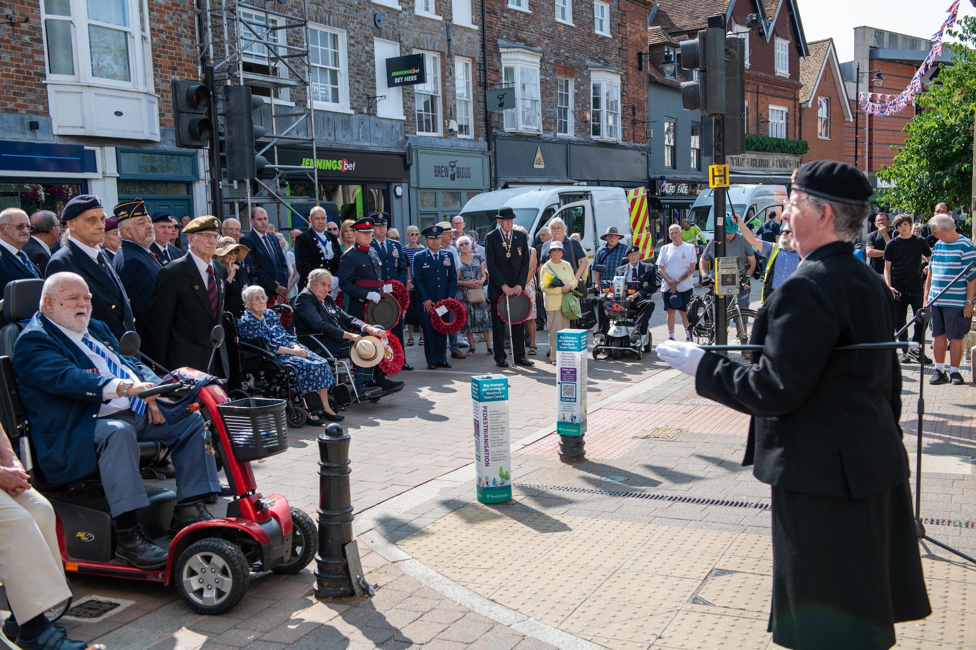 Community members observe a moment of remembrance during the 80th anniversary Victory over Japan Day ceremony