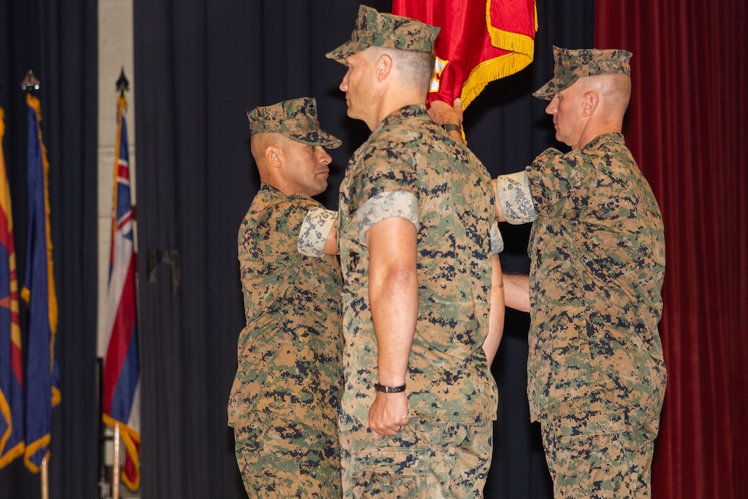 U.S. Marine Corps Sgt. Maj. Nickie Bautista, senior enlisted leader of Marine Corps Air Station Cherry Point, passes the organizational colors to Col. Brendan C. Burks, right, outgoing commanding officer of MCAS Cherry Point, during a change of command ceremony at MCAS Cherry Point, North Carolina, Aug. 15, 2025. Burks served as the commanding officer of MCAS Cherry Point since August of 2022, this ceremony marked the official transfer of authority and leadership of MCAS Cherry Point to Col. Timothy R. Drieslein. (U.S. Marine Corps photo by Cpl. Andre Marshall)