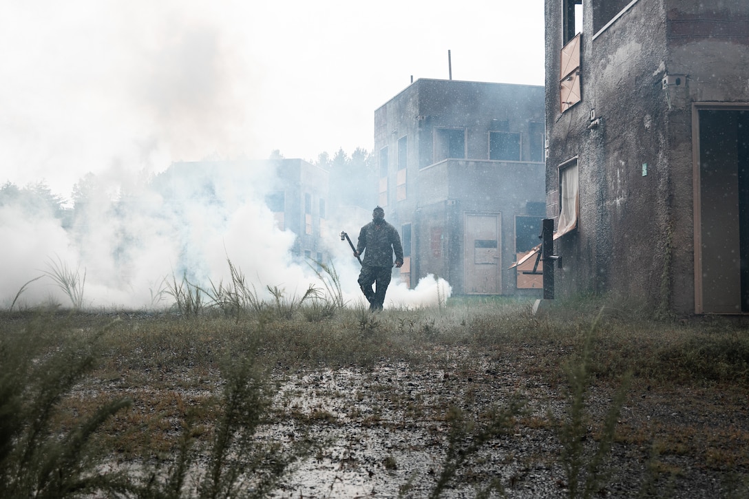 U.S. Marine Corps Sgt. Hunter Cadena, a chemical, biological, radiological, and nuclear (CBRN) defense specialist with 2nd Battalion, 2nd Marine Regiment, spreads chlorobenzylidene malononitrile (tear gas) around a simulated urban area during urban operations training at Marine Corps Base Quantico, Virginia, July 31, 2025. 2nd Battalion, 2nd Marines, the ground combat element of the Special Purpose Marine Air-Ground Task Force-Alert Contingency MAGTF, and Combat Logistics Battalion 22, the logistics combat element of the SPMAGTF-ACM, conducted a deployment for training in order to maintain operational readiness and enhance overall unit cohesion. (U.S. Marine Corps photo by Cpl. Osmar VasquezHernandez)