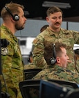 Alt text: uniformed U.S. Marine, U.S. Airman, and Royal Australian Air Force member talking