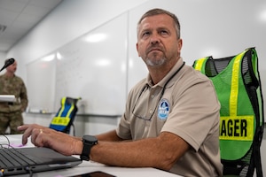 The emergency operations manager types at his desk.