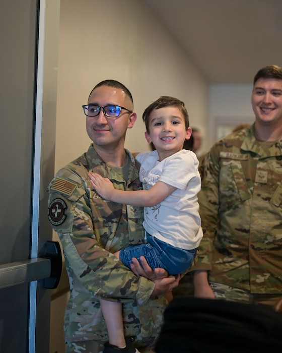 U.S. Air Force Senior Airman Albert Abrego, 17 Healthcare Operations Squadron medical logistics airman, holds his son during the 25E5 Staff Sergeant Release Party at the Powell Event Center, Goodfellow Air Force Base, Texas, Aug. 18, 2025. Staff sergeants are the backbone of the Air Force as the first rank of noncommissioned officers and the frontline supervisors who develop their subordinates, develop themselves further, and ensure proper use of resources under their control. (U.S. Air Force photo by Senior Airman Evelyn J. D’Errico)