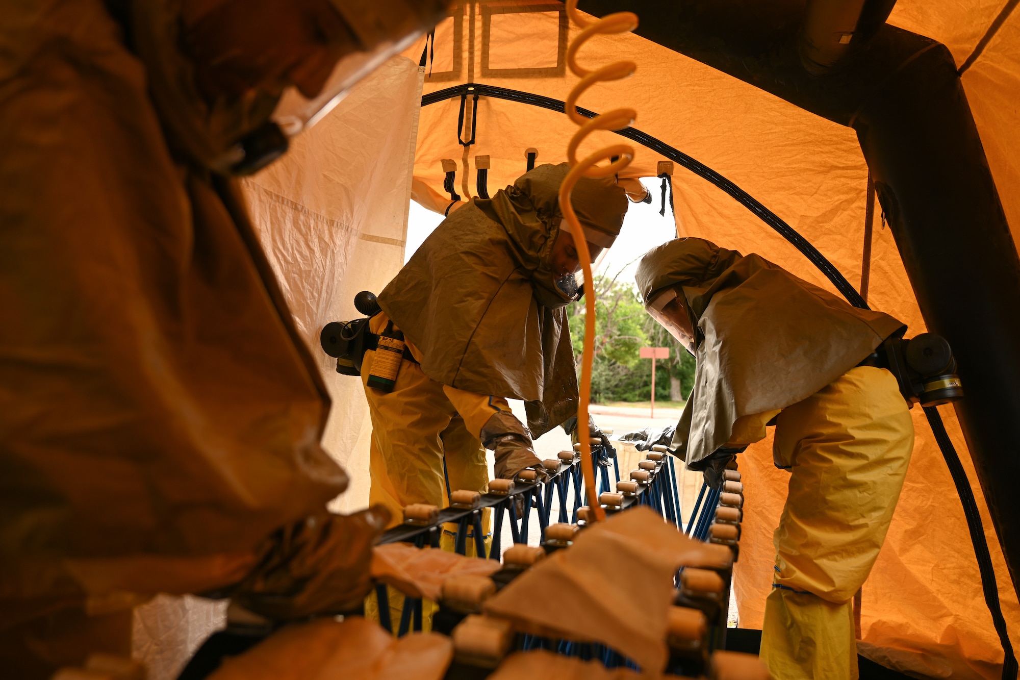 Members are inside the decontamination tent setting up rollers for patients to be brought in.