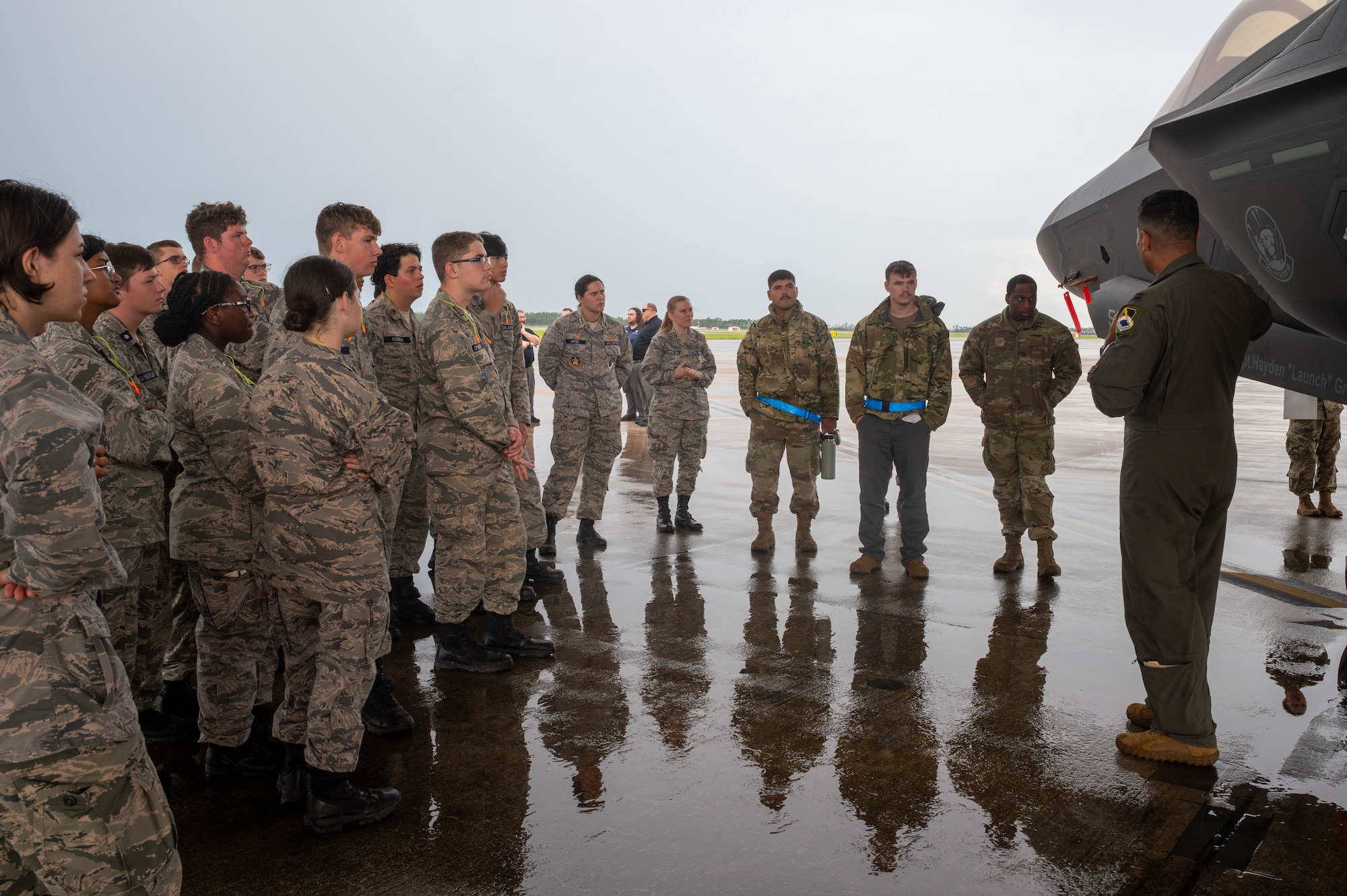Cadets in uniform look at a jet.