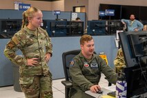 uniformed U.S. Airmen work at computers