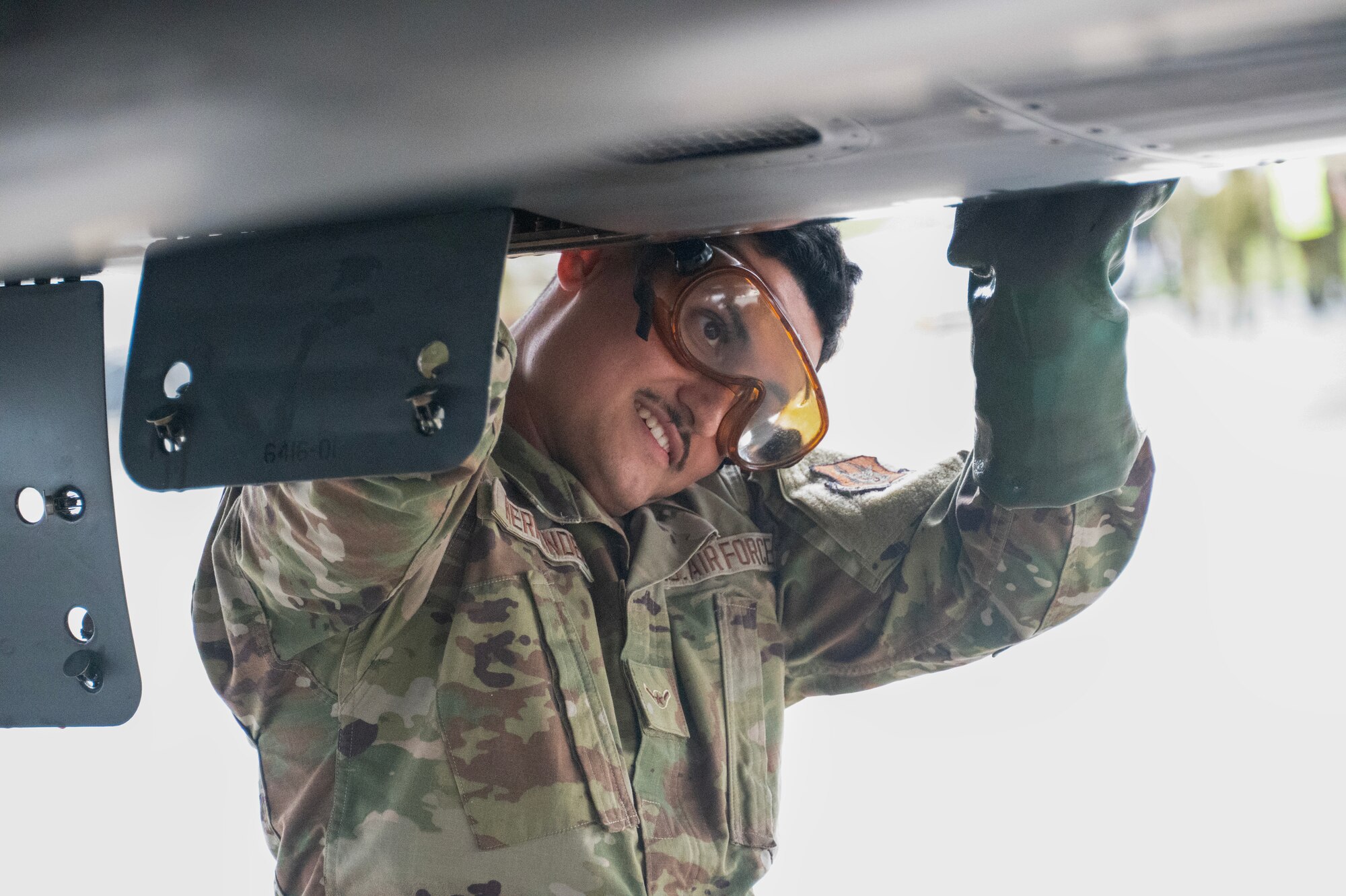 An airman walks around a plane
